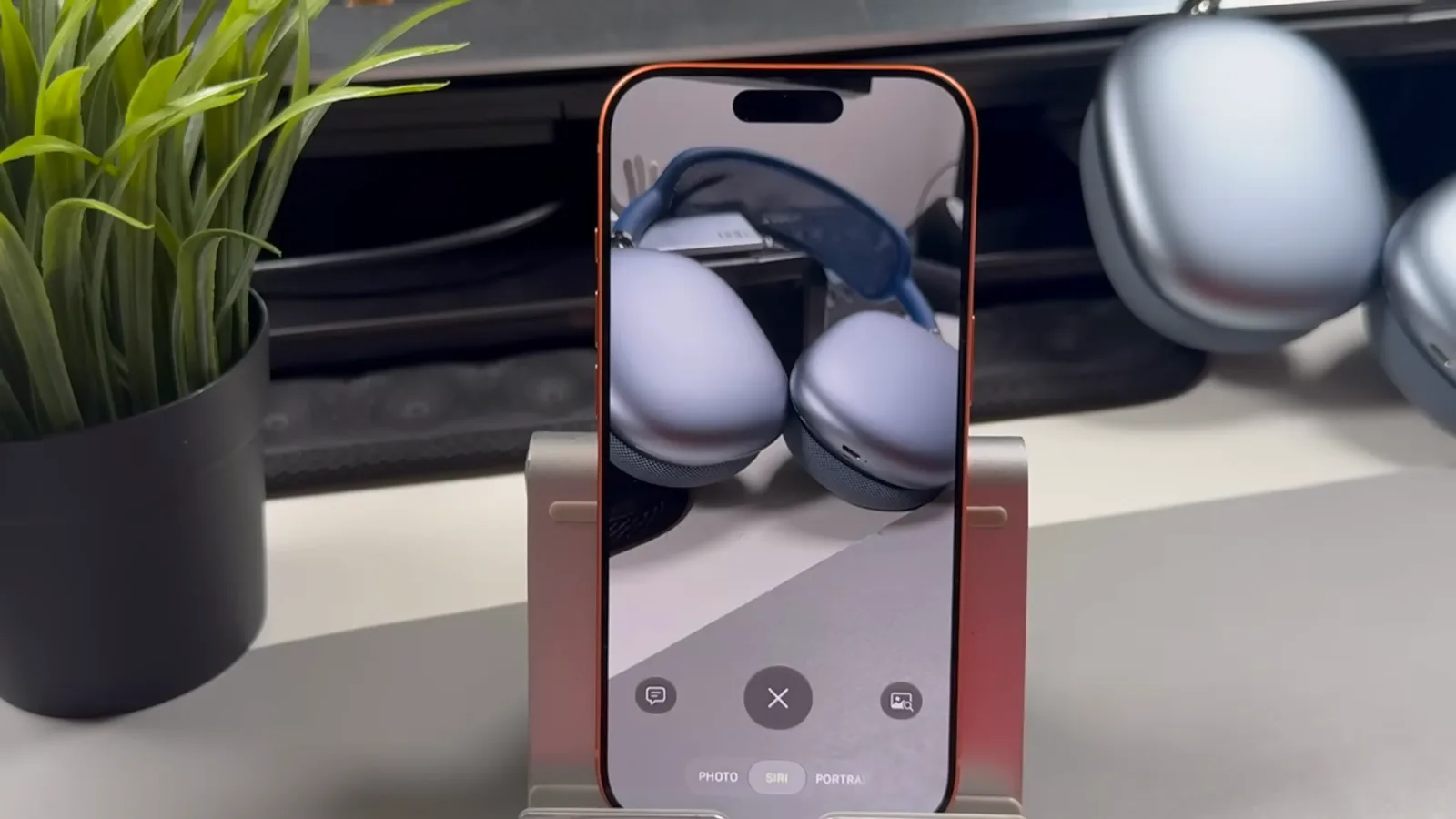 iPhone 相机切到 Siri 模式对准蓝色 AirPods Max，模式条上 Siri 选项高亮