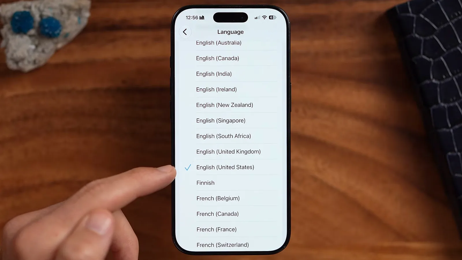 iOS 27 的 Siri Language 选择列表，手指正选中带对勾的 English (United States)