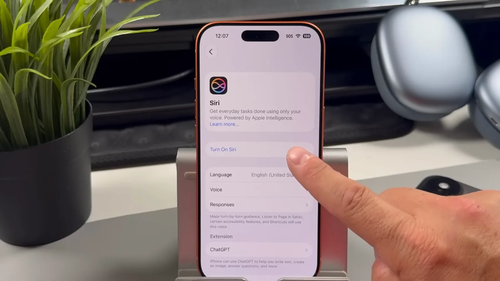 iPhone 设置里的 iOS 27 新 Siri 页面，手指正点按 Turn On Siri 按钮