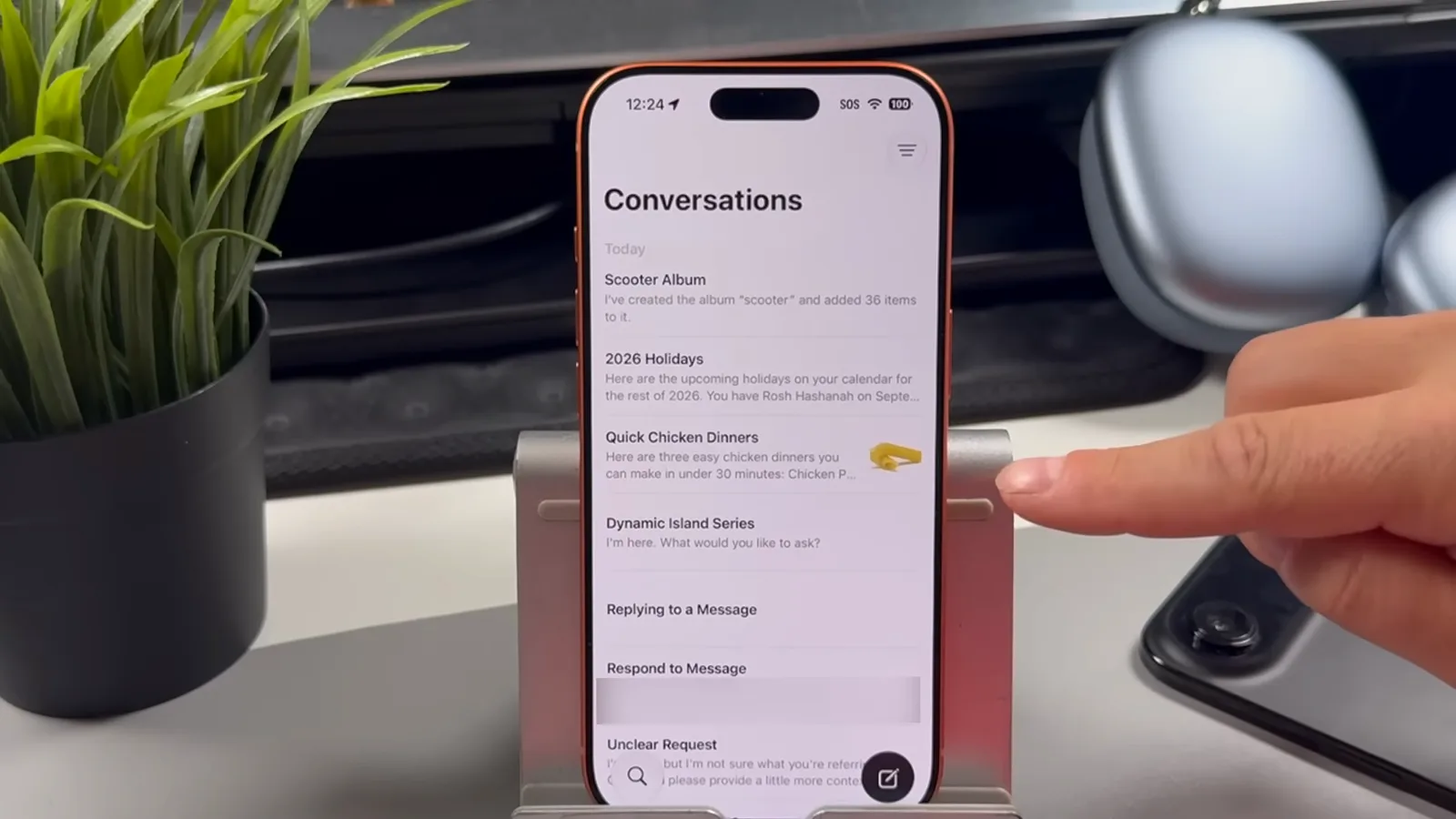 iPhone 上 Siri App 的 Conversations 列表，显示 Scooter Album、2026 Holidays、Quick Chicken Dinners 等会话